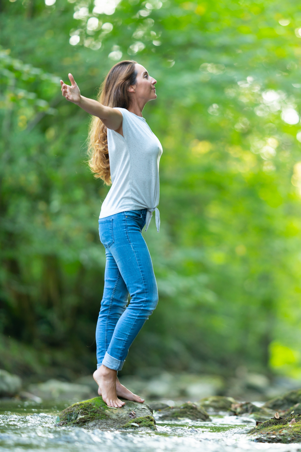 Woman practicing calming breathing techniques outdoors to reduce stress and clear the mind